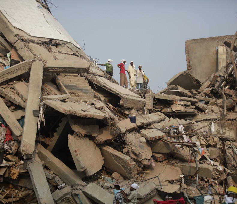 Die eingestürzte Textilfabrik Rana Plaza. Menschen stehen auf den Trümmern.