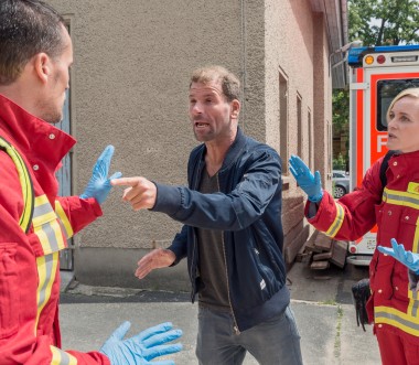 Eine zivile Person bedroht einen Feuerwehrmann.